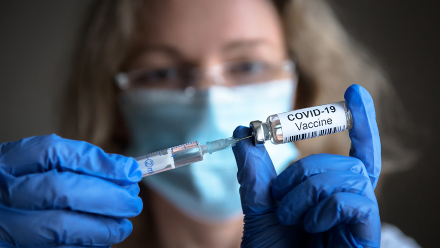 Mulher segura dose da vacina contra a covid-19