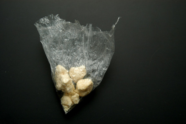 Embalagem de plástico com porção de crack em fundo escuro
