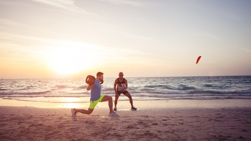 Pessoas praticando exercÃ­cios sob a luz do sol em um ambiente que estimula a serotonina.