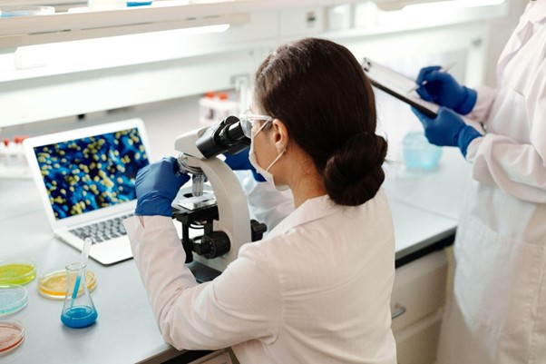 Pessoas utilizando recursos digitais e IA para pesquisar e aprofundar conhecimentos em biologia.